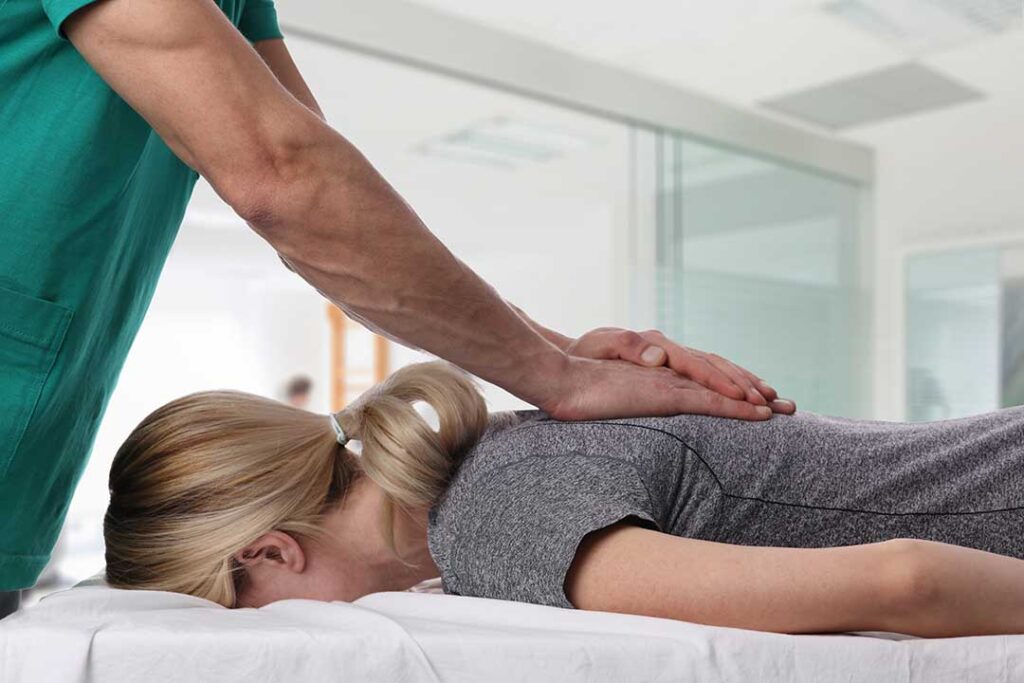 A chiropractor gently adjusting a patient's spine in a comfortable clinic setting.